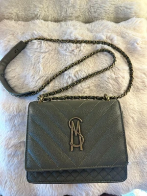 Steve Madden axelremsväska  - Säljer min Steve Madden Bamara axelremsväska i färgen olive. Väskan är i mycket fint skick och har endast använts vid ett fåtal tillfällen. Den är rymlig nog för det viktigaste i vardagen och samtidigt smidig att bära över axeln.   Mått: Höjd: 15 cm Längd: 20 cm Vidd: 8 cm   Köptes för 1 195 kr på Zalando🌟 Hör av dig vid frågor!