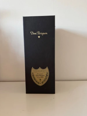Dom Pérignon förpackning - Säljer denna snygga svarta ”champagne förpackningen” från Dom Pérignon, tillverkad i hård kartong med guldfärgad logotyp och emblem på framsidan. ”Fläckarna” som syns är damm. 