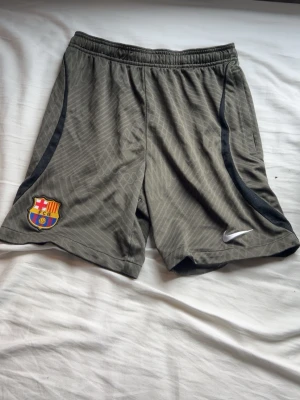 Nike FC Barcelona shorts  - Snygga militärgröna  sportshorts från Nike med FC Barcelona-logga på vänster ben Perfekta för träning eller fotbollsmatcher. Andvända fåtal gånger, därav inga defekter. Skriv vid intresse✌🏼