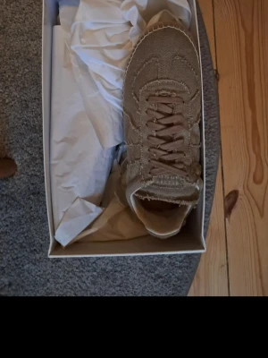 Maison marigelas helt nya  - Snygga beige sneakers från Nike i canvasmaterial med klassisk swoosh på sidan. Skorna har en hög siluett och matchande beige snörning. Perfekta för dig som gillar stilrena och neutrala färger. Kommer i originalkartong. Pris kan diskuteras vid snabbaffär