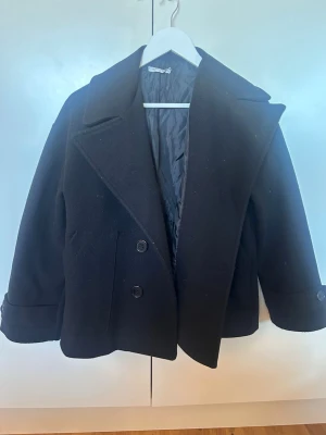 Svart kappa - Svart kappa från designe by si. Jätte fin och inte använd många gånger. Kommer tyvärr inte till användning för mig 