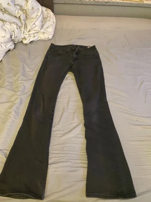 Svarta bootcut jeans crocker - Säljer ett par svarta bootcut jeans med klassisk femficksdesign och normal midja. Jeansen har utsvängda ben och är tillverkade i ett mjukt denimtyg som ger en snygg siluett. Perfekta för dig som gillar en retroinspirerad look.