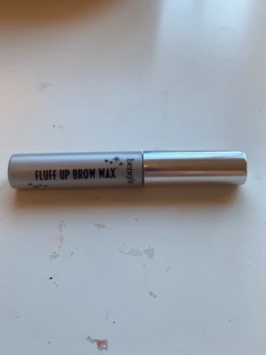 Benefit Fluff Up Brow Wax 1,5 ml - Säljer ett Fluff Up Brow Wax från Benefit på 1,5 ml. Perfekt för att forma och styla ögonbrynen med en flexibel och texturiserande formula. Kommer i en smidig tub med borste för enkel applicering. Mycket kvar! Blir inte alls onajs när det torkar, som jag har upplevt med andra liknande produkter🥰buda gärna🤗