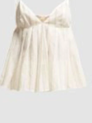Vit ärmlös linnetopp med volang - Söt vit linnetopp med tunna axelband och volangdetaljer. Toppen har en luftig och flowy passform, perfekt för varma dagar. Materialet känns lätt och fräscht, och toppen har en feminin look med en liten rosett framtill.