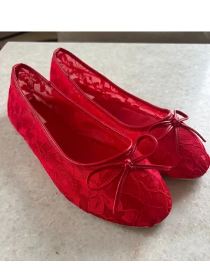 Röda Ballerinas - Snygga ballerinaskor i klar röd färg med spetsdetaljer och en söt rosett framtill. Skorna har rund tå och låg profil, vilket ger en klassisk och feminin look. Perfekta för att addera färg till din outfit.