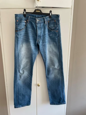 Blåa Levi’s 504 - Klassiska blå jeans från Levi's med rak passform som är extremt lika 501. Storlek W 34 L 32. Jeansen har en snygg wash och fades som whiskers och honeycombs börjar skapas. Se bättre på sista bilden. Tillverkade i Mexico i 100% bomull. Tveka inte att höra av dig om du har några frågor.
