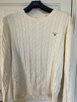 Vit premium cotton kabelstickad tröja från GANT - Mycket fint skick!!  Kabelstickad vit tröja från GANT. Klassisk och stilren design i mjukt material. 