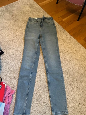 Ljusblå skinny jeans  - Säljer ett par ljusblå skinny jeans från Minup i storlek 36. Jeansen har hög midja, klassisk femficksdesign och är tillverkade i stretchigt denimtyg för en bekväm passform. Perfekta till en avslappnad och trendig look.