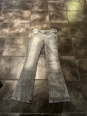 Grå bootcut jeans med slitning - Jeansen är low Waits i storlek i w27, mått kan skickas! Super fint skick men pris går att diskutera! Materialet är denim i bomull 