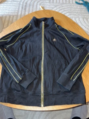 Moose Knuckles tracksuit - Svart Moose knuckles dress med gula detaljer. XXL Passar XL.