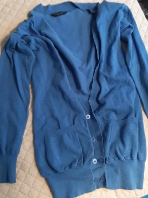 Ljusblå midi-lång kofta från Dorothy Perkins  - Beautiful,  midi-long cardigan in light-wheat blue colour from Dorothy Perkins. In very good condition. Size 40/L on label, I think it fit for size 42/XL too.