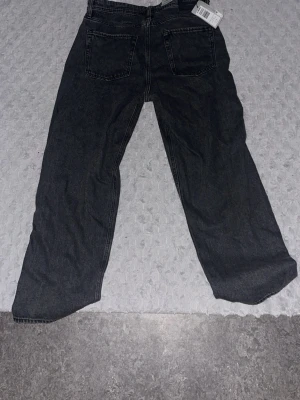 Svarta raka jeans från JJ REBEL - Snygga svarta jeans från JJ REBEL med raka ben och klassisk femficksdesign. Jeansen har en mörk tvätt och är tillverkade i denim. Perfekta för dig som gillar en avslappnad och trendig stil. Aldrig använt dem!!