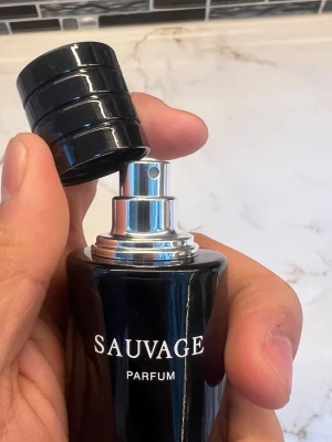 Sauvage Parfum från Dior - Sauvage Parfum från Dior i en elegant, mörkblå flaska med silverdetaljer och svart lock. Flaskan har en stilren och modern design med tydlig logga framtill. Perfekt för dig som vill ha en ikonisk och lyxig doft i samlingen.