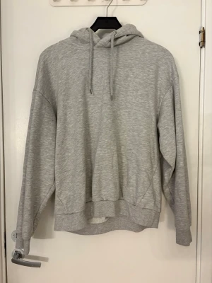 Ljusgrå basic hoodie med huva - Ljusgrön hoodie med luva. Den har ingen ficka på magen. Den är väl använd så den har lite knottror på sig