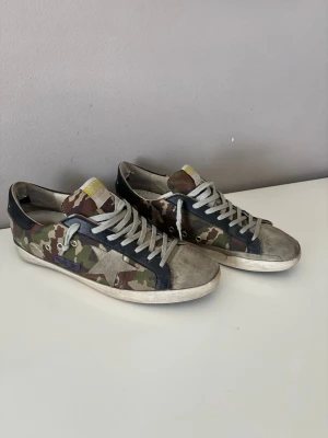 Kamouflage Golden Goose skor - Perfekta sommarskorna. Säljer nu mina ganska unika golden goose skor i kamouflage, säljer för att dom tyvärr inte passade mig när dom kom hem, men hade garanterat använt dom här hela sommaren om dom suttit bra, storlek 45 men skulle kunna passa 46- större 44/44,5