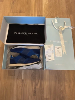 Blå Philippe Model sneakers - Snygga blå sneakers från Philippe Model med ovandel i mocka köpta på en Philippe model äffar i Milano dustbag ingår och hela förpackningen. Ordenarie pris 2700. 