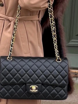 Svart väska  - Svart quiltad flap bag säljes. Superfin klassisk modell med elegant kedjerem och tidlös design. Passar både till vardag och fest och lyfter vilken outfit som helst.  Använd men i fint skick, med normala tecken på användning. Säljes vidare då den inte kommer till användning. ✨