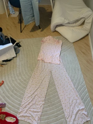 Ljusrosa pyjamas med citronmönster - Supermjuk ljusrosa pyjamas från 157 med sött citronmönster. Setet består av en kortärmad topp och vida byxor i tunt, skönt material. Perfekt för mysiga hemmakvällar och lata morgnar. Byxorna passar som S och M och L