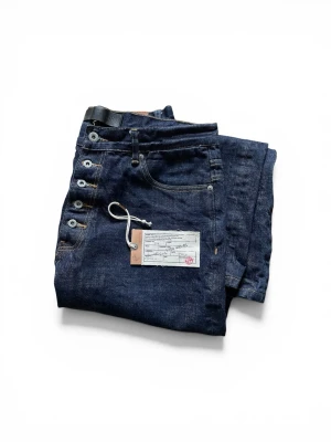Japanese selvedge denim - Baggy jeans från NoFaithStudios i kraftig denim av hög kvalitet (Japanese selvedge), vilket ger en cool och tidlös look. Modellen har synliga silverfärgade knappar och en klassisk femficksdesign. Använda vid ett fåtal tillfällen – har dock krympt något efter första tvätten. Hör gärna av dig om du vill ha exakta mått!