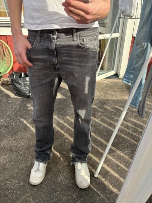 Bootcut Replay jeans - Säljer dessa feta mörkgråa Replay jeans. Har klippt upp de där nere så att de blir en fet bootcut, tyvärr är de några prickar på knät som inte försvinner men de syns inte. Står inte waist men passar som waist 30