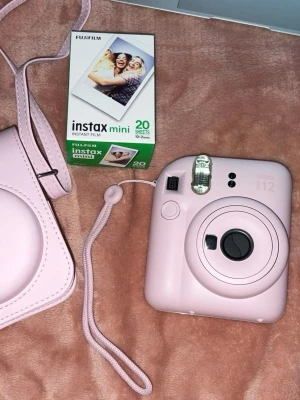 Rosa Fujifilm Instax Mini 12 - Säljer min rosa Instax Mini 12. Fodral och 20 st fotopapper följer med. Använd vid två tillfällen, har haft den i 3v. 🌺