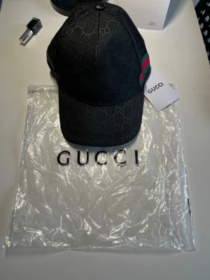 Svart designer keps – ny med tags & dustbag 🧢 - Säljer en stilren svart monogram keps i premium kvalitet. Helt ny och oanvänd med tags kvar samt medföljande dustbag/påse. Klassisk modell som passar till allt och ger en clean streetwear-look. Perfekt som present eller till dig som vill uppgradera outfiten.  Skick: Ny Färg: Svart Tillbehör: Tags + påse ingår Pris: 300kr  designer keps, svart keps, monogram keps, luxury cap, streetwear keps, snapback/strapback keps, premium keps, fashion keps, unisex keps, ny keps med tags