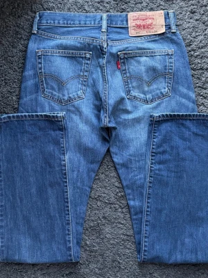 Levis 501 Jeans Vintage - Levis 501 med lätt bootcut.  Färg: Blå med fades | Modell: 501 | Storlek: W30 L34 | Vintage Premium Jeans  Mått: Midja: 38,5 cm Längd: 110 cm Beslut: 20,5 cm Lår från grenen: 26cm  Tveka inte att höra av dig minsta fråga eller fundering!  Skickas snabbt!