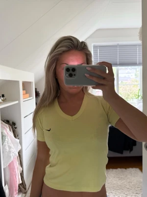 Gul vintage Nike T-shirt  - Snygg gul vintage t-shirt från Nike med v-ringning och korta ärmar. Liten svart Nike-logga på bröstet. Står ingen storlek i den men passar mig som är xs. 
