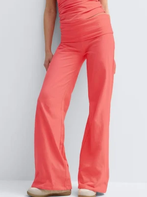 Vida korallfärgade yogapants - Snygga vida byxor i en stark korallfärg med hög midja och stretchigt material. Byxorna har en slät front utan synliga fickor eller dragkedjor och är perfekta för en trendig och avslappnad look.
