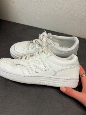 Vita New Balance sneakers  - Snygga helvita sneakers från New Balance. Storlek 38. De har några fläckar som inte går bort men annars är dem i bra skick.