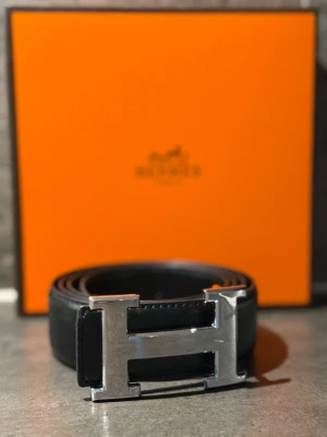 H&M bälte  - Pris kan diskuteras vid snabb affär. Snyggt svart skärp  med ikoniskt H-spänne i silverfärgad metall. Skärpet är gjort i exklusivt kalvskinn och levereras i original orange H-box. Perfekt accessoar för att lyfta din outfit.