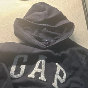 GAP Hoodie - Tjenare säljer en vintage/äldre modell av GAP Hoodie. Köptes 2015 och har varit under min ägo ända sen dess. Skön hoodie med ull-likt material i luvan. Skick 7/10 Saknar endast snören. Storlek: M. Vid några funderingar är det bara att skriva ! 👏