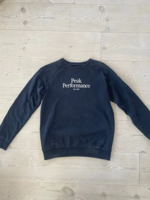Mörkblå Peak Performances sweatshirt  (Barn) - Mörkblå sweatshirt från Peak Performancens i storlek 160, använd fåtal gånger och i mycket bra skick 