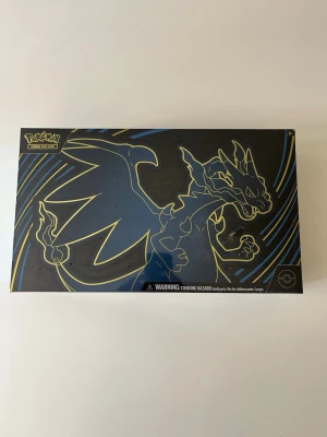 Pokémon Mega Charizard X EX Ultra Premium Collection - Pokémon Mega Charizard X EX Ultra Premium Collection i nyskick, ej öppnad med plast på.  2 UNIT LIMIT 18 TCG Pokémon Booster Packs 2 Promo Cards 1 Coin and 1 Code Card 6 Damage Counter Dice 1 Playmat and 1 Deck Box