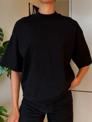 Oversized svart t-shirt  - Oversized svart t-shirt med klassisk rund hals och korta ärmar. Tillverkad i mjuk bomull som känns skön mot huden. Perfekt för en avslappnad och stilren look.