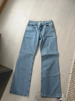 Blåa raka jeans med hög midja från NAKD - Säljer ett par klassiska blå jeans med rak passform och hög midja. Jeansen har fem fickor och stängs med dragkedja och knapp. Perfekta för en avslappnad och trendig look.Jag är cirka 172 cm men kan också sys upp. 