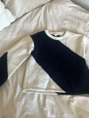 Vit stickad tröja med mörkblå ränder - Säljer den populära vit och mörkblå stickade tröja med diagonala ränder. Tröjan är fluffig och varm. Köptes på Gina tricot för 300kr🩷