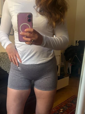 Grå Gymshark shorts - Gråa Lift Seamless gymshorts från Gymshark! Mjuka, stretchiga pch så sköna! De är väldigt smickrande emd en högre midja och scrunch baktill. Har använt en del men finns inga tecken på användning och de är fortfarande i gott skick!🩶🤍