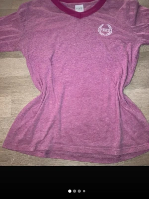 Rosa t-shirt från Victoria's Secret PINK - Säljer en rosa tröja från Victoria's Secret PINK med v-ringning och mörkare rosa kant.