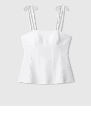 Vit korsettopp med knytband - Stilren vit korsettopp med smala axelband som knyts upptill. Toppen har en figurnära passform och markerade sömmar framtill för en snygg siluett. Perfekt att styla med jeans eller kjol för en trendig look.