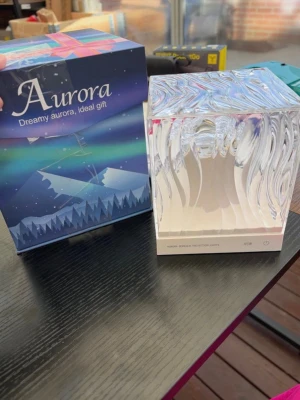 Aurora ljusprojektor kub - Säljer en Aurora ljusprojektor i form av en transparent kub med vågigt mönster. Projektorn skapar norrskenseffekt och har en modern, stilren design. Perfekt som dekorativ belysning i rummet. Levereras i originalförpackning.