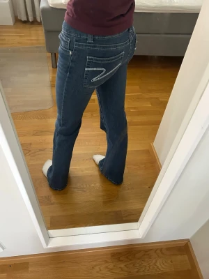 Blå bootcut jeans från 7 For All Mankind - Säljer ett par blå bootcut och low waist jeans från Din Vintage Shop. Jeansen är i storlek XS och är normala i storleken. Passar mig som är 168 cm!