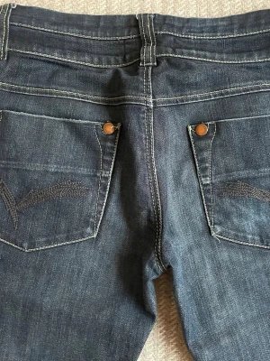Lågmidjade jeans - Mörkblå  lågmidjade jeans från VILA. Köpt second hand😻 Skit snygga men kommer aldrig till användning. Har snygg broderi på bakfickorna!!!💞 Strolek 27 men jag som har Xs/S passar dem super bra som ni ser på bilderna🥰skriv om ni har några funderingar eller vill ha mått 📏 pris kan absolut diskuteras