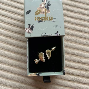 Guldfärgad ring med pil och hjärta - Super snygg ring från IOAKU X Svea &Isabelle! Den är använd nån gång, men vart väl omhändertagen! Så inget slitage (originalförpackning kommer med).  Nypris 599! Säljer för 300