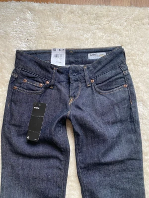 Helt nya mörkblå lågmidjade Lee jeans - Mörkblå/svarta. midjan rakt över:34cm innerben:85cm