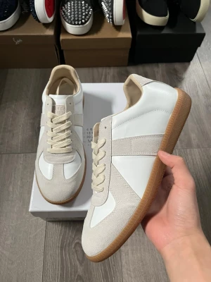 Maison Margiela vita sneakers - Maison Margiela sneakers i vitt läder och beige mocka med klassisk gummisula🤩 Storlek 41 i bra skick.Här av er hid funderingar samt snabbaffär😇 Pris är ej hugget i sten🤗