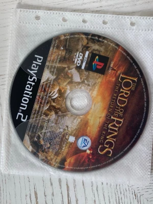 Sagan om ringen: Konungens återkomst PS2 - PlayStation 2-spel The Lord of the Rings: The Return of the King. Hairlines och repor finns på skivan.