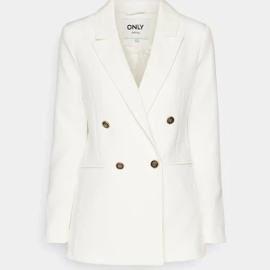 Vit dubbelknäppt kavaj från ONLY - Stilren vit kavaj från ONLY med dubbelknäppning och fyra dekorativa knappar framtill. Klassisk krage och två fickor framtill. Lång ärm och rak passform ger en snygg siluett. Perfekt till studenten om man ej vill ha klänning, används endast en gång under studentfirande. Har en liten fläck som inte är jätte märkbar men vid behov skickar jag bild på den! Prislapp sitter kvar då jag glömde dra loss den🙃 (kan skicka fler bilder om jag letar)