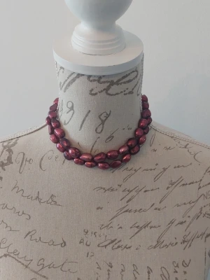 Vinrött pärlhalsband dubbelt - Snyggt halsband med två rader infärgade vinröda/röda odlade pärlor. Halsbandet har en rund, silverfärgad låsdetalj. Köpt på Vilda, pärlaffär på Odengatan Stockholm för 495 kr och har varit med i ett brudmagasin. Perfekt för dig som vill ha något unikt och färgstarkt till din stil.