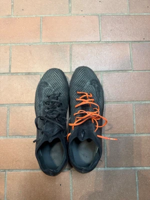 Nike Mercurial Vapor 16 Elite AG  svarta - Säljer ett par svarta fotbollsskor med mönstrad ovandel. Skorna har klassiska dobbar för spel på konstgräs och är tillverkade i syntetmaterial. Perfekta för dig som vill ha diskret stil på planen.